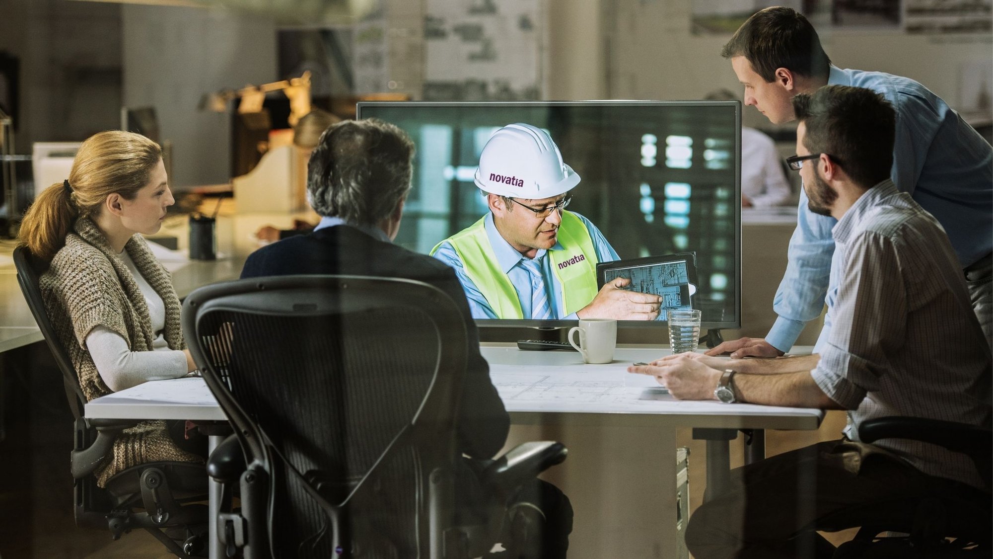 Man on virtual screen with people at a desk-2